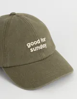 Gorra de gabardina color verde oliva con visera curva y bordado frontal en relieve con la frase "good for sunday".