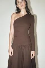 Vestido midi marrón de escote asimétrico con un hombro descubierto y una manga larga. La falda es amplia con bolsillos laterales y bajo tipo globo.