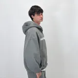 Canguro gris con cierre frontal, capucha y cordones ajustables. Estampado con logo en el pecho.