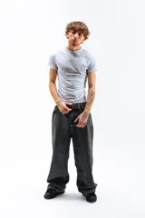 Pantalón de jean azul desgastado, corte mega baggy, con bordado dorado en el bolsillo trasero y botones personalizados.