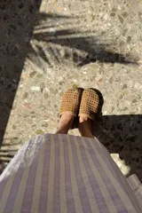 Túnica de lino a rayas verticales color lila y blanco, con cuello polo y bordado de un pulpo azul en el frente.