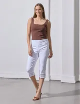 Pantalón capri blanco de gabardina elastizada con bolsillos simulados, pretina ancha, corte recto y detalle de puntilla en el ruedo.