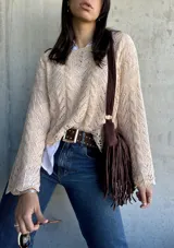 Sweater beige de punto calado con mangas acampanadas.