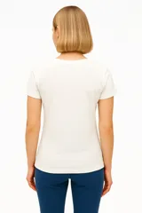 Remera negra de algodón con cuello en V y estampado de flores blancas.