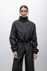 Campera cropped negra de tela campera repelente al agua, con interior de micropolar, cuello alto, cierre frontal a tono, bolsillos funcionales y puños elastizados.