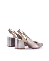 Zapatos plateados de cuero metalizado, con punta fina, talón descubierto y tira con hebilla ajustable. Taco geométrico de 7 cm.