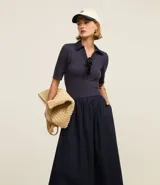 Vestido midi con corte godê, confeccionado en rib de viscosa en la parte superior y tricolina de algodón en la falda. Presenta cuello polo y mangas cortas.