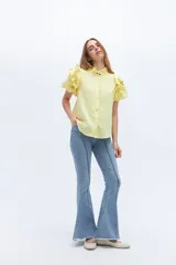 Pantalón de jean acampanado celeste con alforza central y ruedo desflecado.