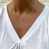Collar de cadena con pequeñas cuentitas y dije en forma de ángel, elaborado en plata 925.