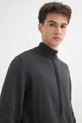 Campera negra de tejido de punto, con cuello alto, cierre frontal y mangas largas.