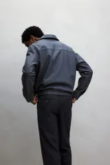 Pantalón de vestir negro de corte recto, con bolsillos laterales y traseros. Se ajusta a la cintura con cinturón.