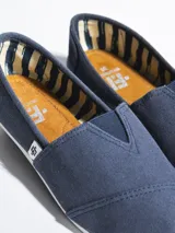 Alpargatas grises de lona con suela de goma blanca.