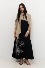 Vestido largo de tirantes color azul con estampado floral blanco en el lateral inferior.