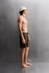 Bañador corto color marrón con cintura elástica negra ajustable con cordón. Tiene un bolsillo lateral con cierre de cremallera y costuras planas termofijadas.