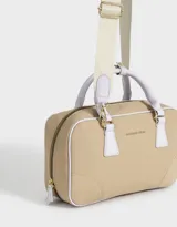 Cartera bowling color beige con detalles en blanco, doble asa corta de mano y correa regulable desmontable.