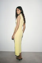 Vestido midi color blanco hueso, sin mangas, con cuello alto y detalle de drapeado fruncido en el lateral izquierdo del torso.