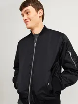 Campera bomber negra Jack & Jones, liviana y cómoda, con cuello estilo baseball, mangas largas con puños acanalados, cierre con cremallera, bolsillos al frente con botón y bolsillo en la manga.