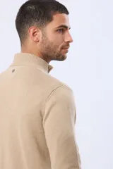 Buzo tejido de algodón color azul marino, con cuello alto y cierre frontal parcial con detalle de cuero en el tirador.