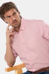 Camisa manga corta color rosa claro con cuello abotonado y bolsillo en el pecho.