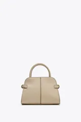 Bolso mini city color beige con doble asa de mano y asa bandolera extraíble. Tiene detalles laterales, pespuntes en el cuerpo y cierre con solapa y botón imantado.