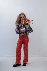 Pantalón de gabardina elastizada color rojo con estampado de flores grandes.