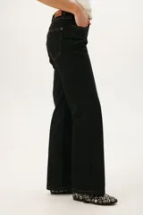 Pantalón de jean negro de corte recto con costuras en color ocre.