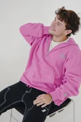 Canguro rosa con cierre parcial, capucha, bolsillo tipo canguro y logo estampado en el pecho y en la manga.