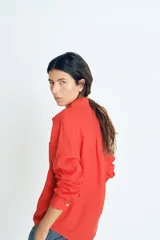 Camisa roja de lino con cuello clásico, botones frontales y bolsillo en el pecho.