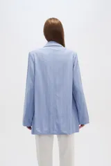 Blazer color blanco con rayas verticales finas, cuello solapa, bolsillos frontales y corte clásico. Confeccionado en lino.