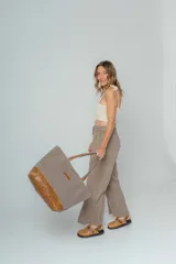 Bolso tipo tote de lona color crudo con base y asas de cuero marrón.