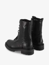 Borcego de caña media de cuero color marrón con efecto envejecido. Presenta sistema de cordones con ojales metálicos y suela track gruesa de goma negra.