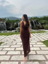 Vestido largo color borgoña, con escote halter y cuello regulable. Tiene forro corto con transferencia y está confeccionado en microtul.