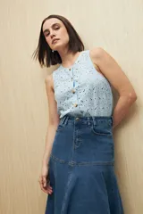 Falda midi de denim azul con corte evasé, cintura alta y bolsillos laterales.