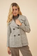 Chaquetón color crema con doble solapa, abrochadura doble, bolsillos delanteros y forro al tono.