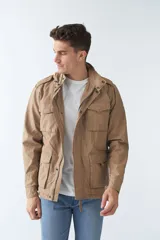 Campera de gabardina azul marino con capucha desmontable y ajustable, bolsillos tipo cartera y cierre frontal con botones.