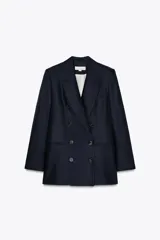 Blazer azul marino de cuello solapa y manga larga con hombreras. Tiene abertura en la espalda y cierre frontal cruzado con botones.