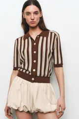 Chaqueta de punto marrón con rayas verticales en blanco y beige, cuello polo, manga corta y cierre frontal con botones.