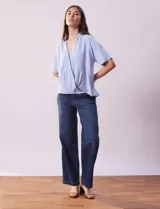 Blusa celeste de lino marca Cupio, con cuello con solapa, escote en V y delantera cruzada.