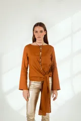 Blusa blanca de lino con escote en V cruzado, mangas largas y lazo en la cintura.