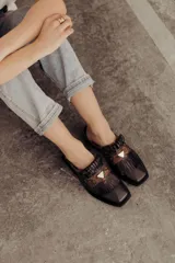 Zuecos de cuero negro con detalle de flecos y pieza central en cuero snake.