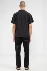 Pantalón de pana negro con cintura elástica y cordón de algodón. Cuenta con bolsillos laterales, un bolsillo trasero y el parche característico de Polonio.