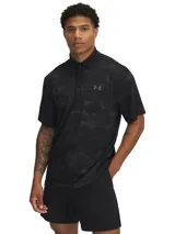 Chomba de golf Under Armour Playoff Polo 3.0 negra con estampado camuflado en tonos oscuros y logo de la marca en el pecho.