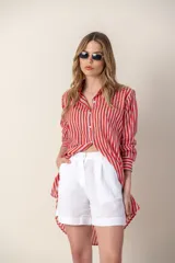 Camisa larga a rayas verticales rojas y blancas, con cuello camisero y cierre frontal con botones.