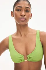 Top de bikini verde con textura, breteles anchos y anilla revestida en el centro del busto.