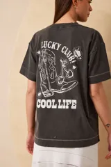 Remera negra de algodón con estampa en la espalda que incluye una bota de cowboy, cerezas, un sombrero y las frases "Lucky Club!" y "Cool Life".