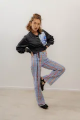 Pantalón largo de gabardina elastizada a rayas verticales azules, rojas y naranjas.