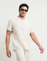 Camisa de manga corta color beige claro, con cuello mao y botones de coco. Confeccionada en mezcla de lino y algodón.