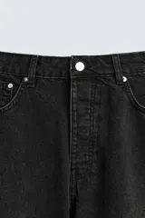 Pantalón de denim color beige, corte relaxed fit, con bolsillos laterales tipo cargo con solapa y cierre de botón. Cierre frontal con botón y cremallera.