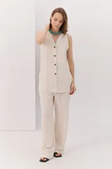 Chaleco color beige confeccionado en lino y rayon, con escote en V y cierre frontal con botones. Diseño clásico y favorecedor.