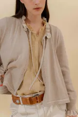 Saco tejido color negro con detalle en escote y puños a dos tonos, corte acampanado y detalle en la espalda con cambio de punto y color.